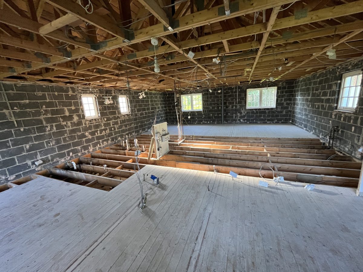 A room stripped back to blockwork and bare joists at the start of a renovation by Concept Joiners