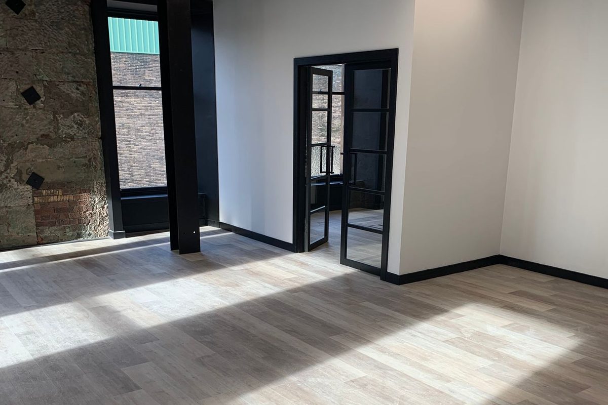 A commercial fit out by Concept Joiners, with exposed stone, black framed doors and new flooring