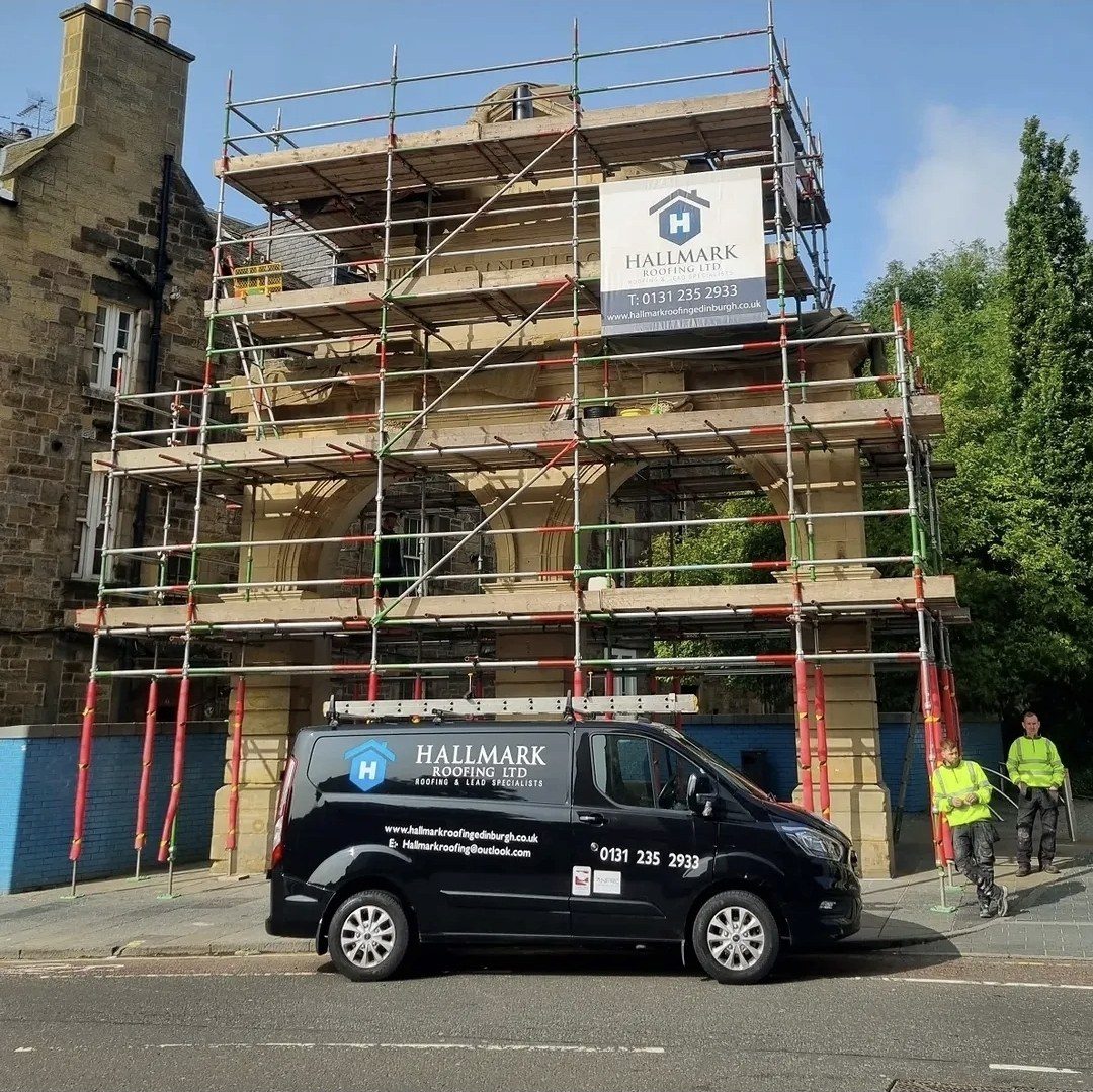 A scaffolded Edinburgh stone building with the Hallmark Roofing banner and branded van outside, Edinburgh Trusted Trader member