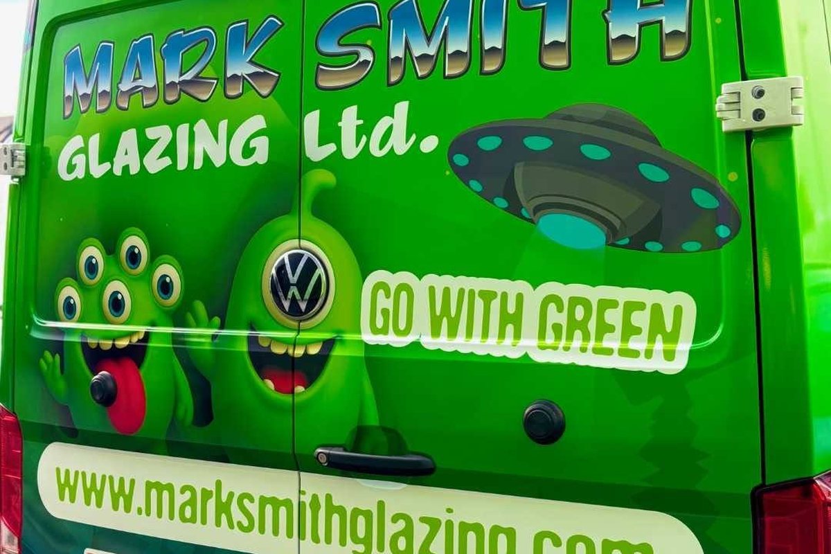The rear of a bright green Mark Smith Glazing van, carrying the company name, website and accreditation logos including Edinburgh Trusted Trader
