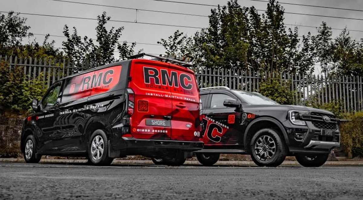 An RMC Double Glazing van and pickup in the company's red and black livery, parked on a cobbled street in Ayr