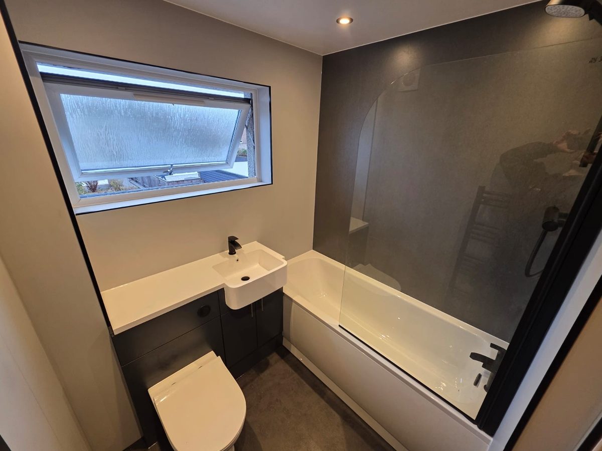 A finished Wishart bathroom in Kirkcaldy with a bath, glass shower screen and wall panelling